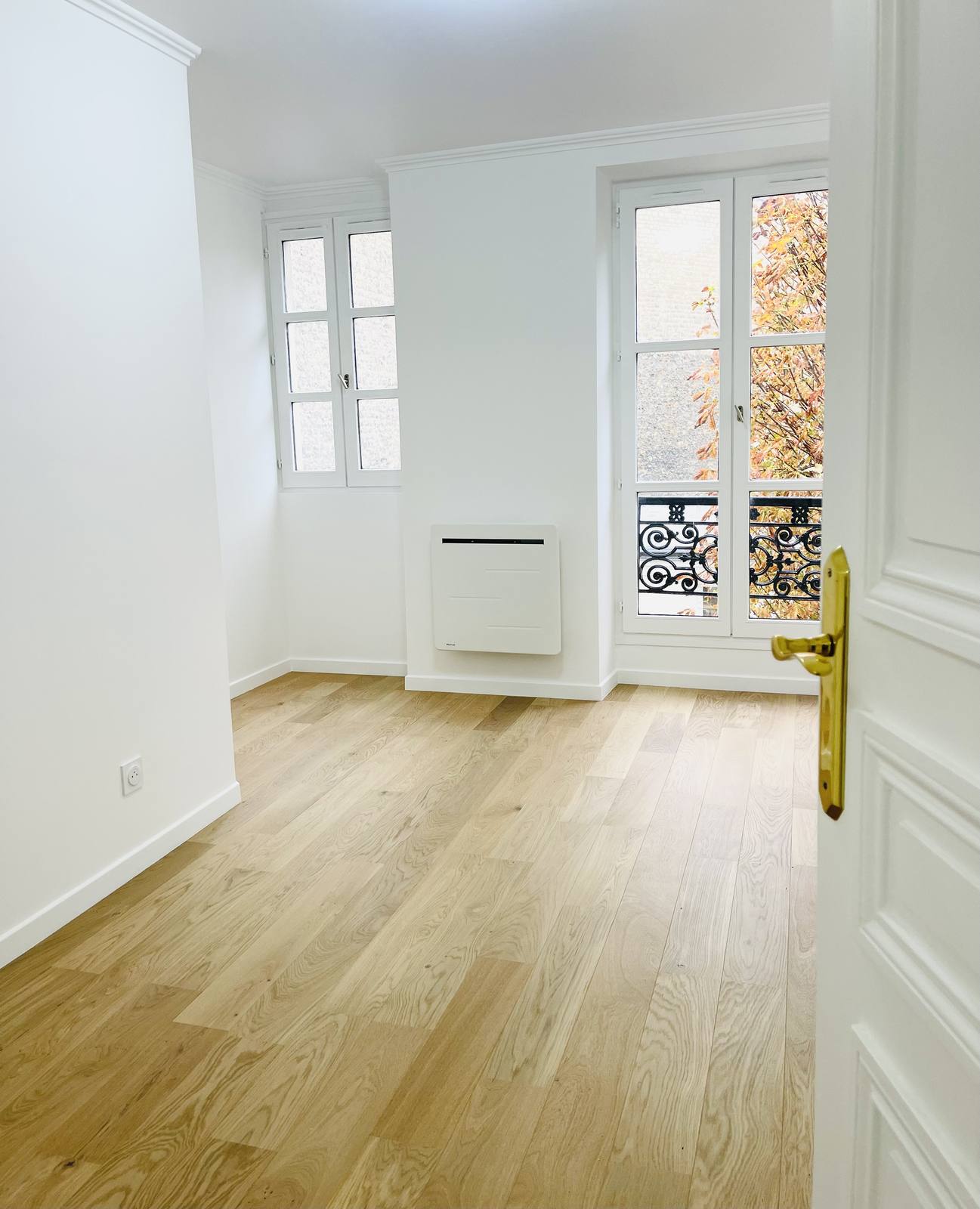 Pièce lumineuse avec parquet et fenêtres parisiennes
