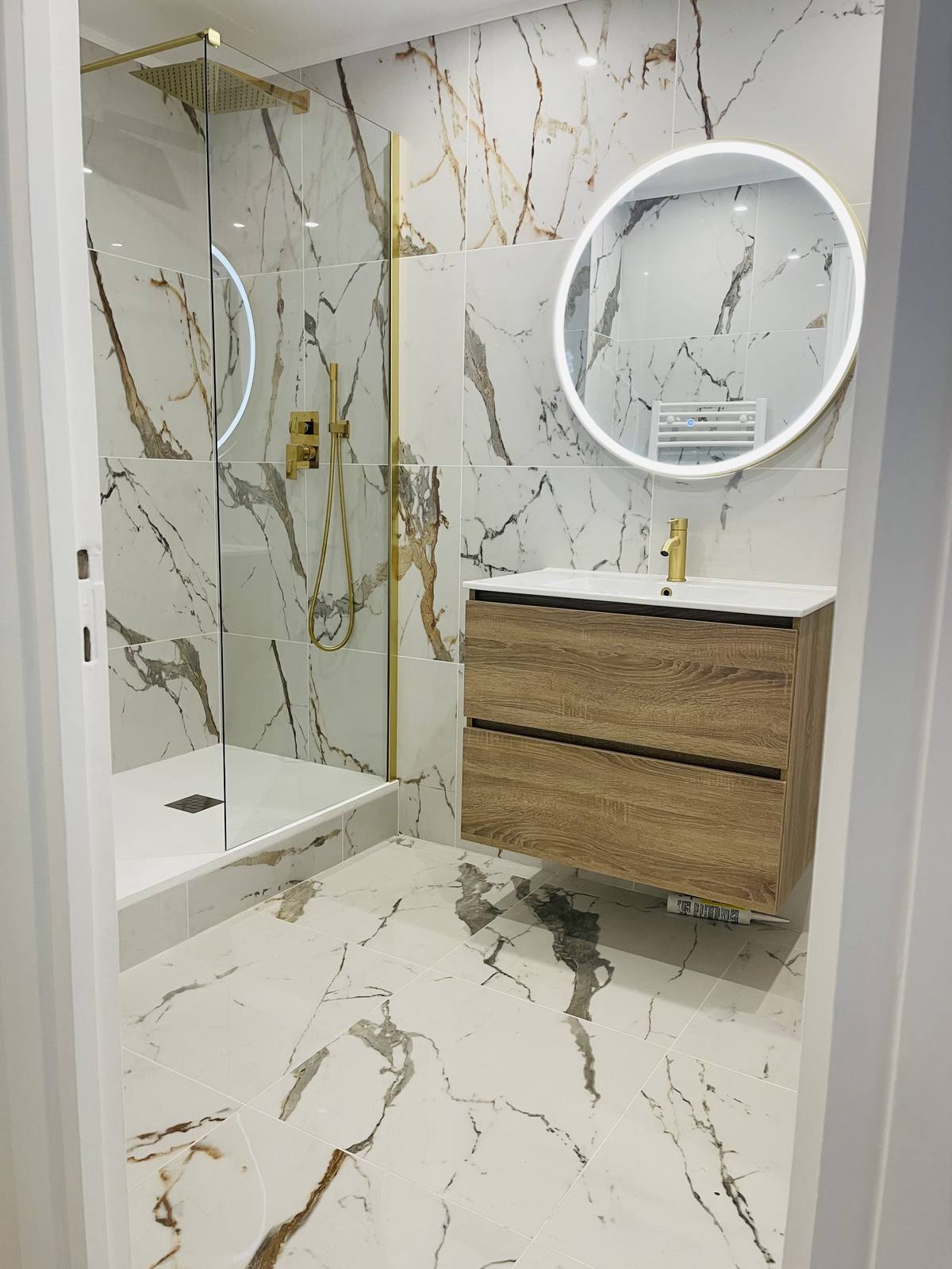 Salle de bain en marbre avec robinetterie dorée